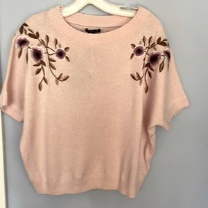 Short sleeved pink embroidered sweater.